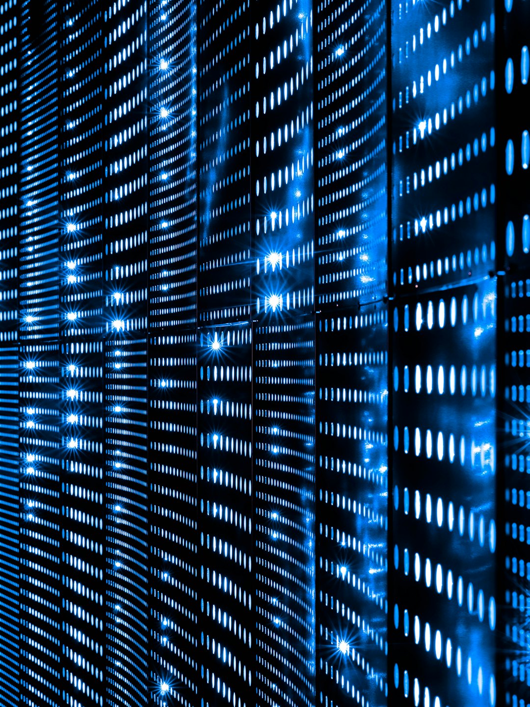 Luces azules abstractas sobre una superficie de rejilla tecnológica oscura.